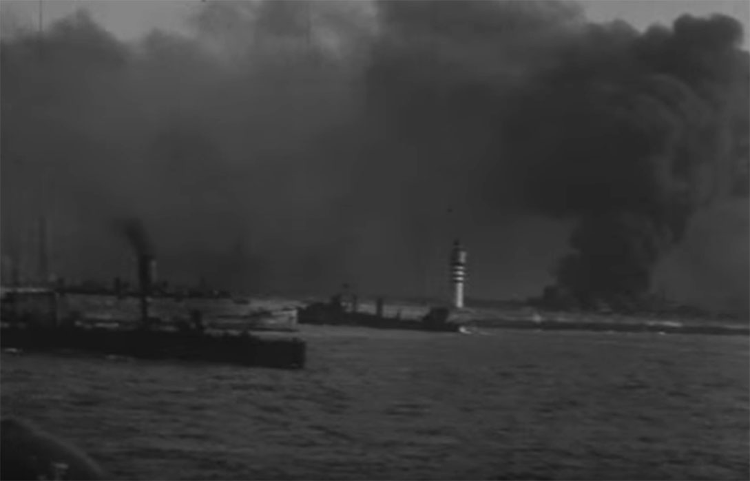 Dunkirk, oil fires burnung and lighthouse at harbour entrance