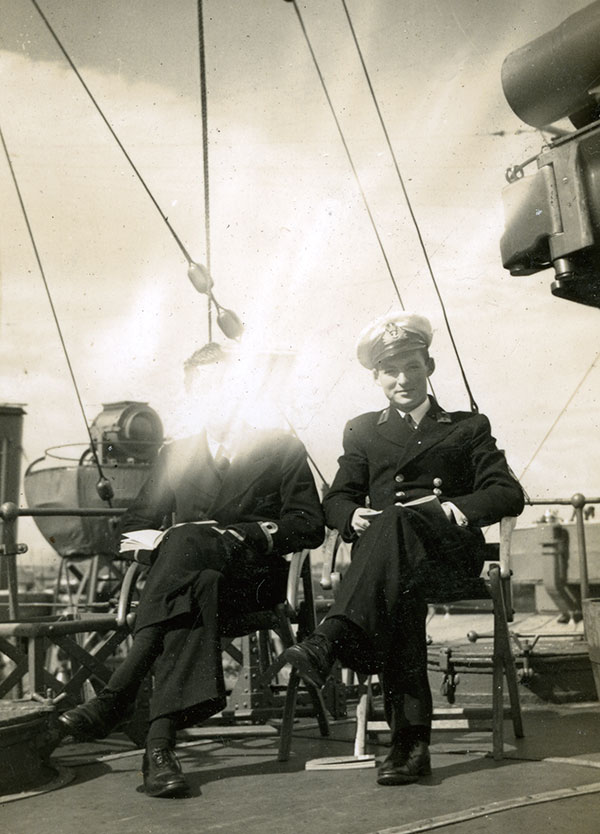 Sub Lt R.G.B. Keyes, the son of Sir Roger Keyes, reading on stern of HMS Wivern with Midshipman Briggs on right